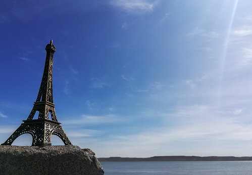 a miniature of the eiffel tower on a rock with landscape view