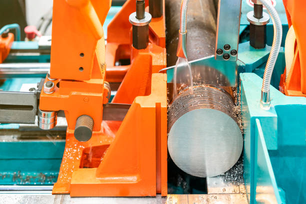 istock Close up Round shaft steel is being cutting by automatic continuous and high speed horizontal band saw machine for industrial with the coolant fluid 1386905309