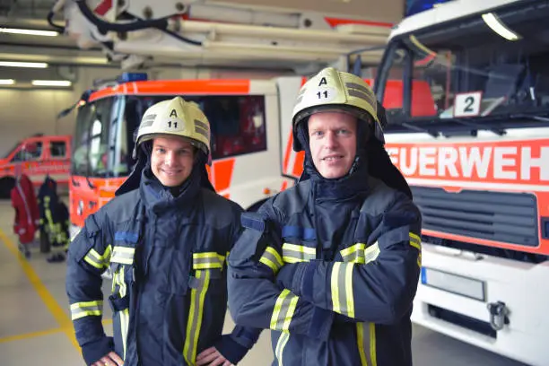 Group of firefighters at the emergency vehicle in the fire station