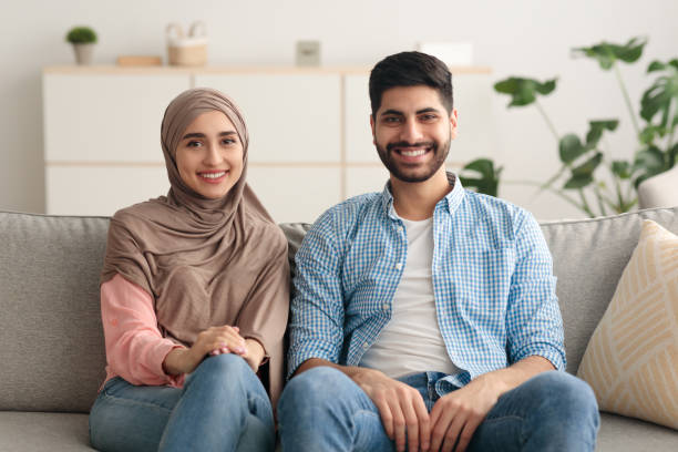 istock Cheerful Middle Eastern Husband And Wife Sitting At Home 1386906152