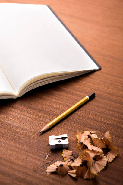 A Study in Creativity: A Notebook Surrounded by an Array of Colorful Pencils. A notebook with a bunch of pencils on top of it