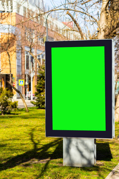 istock Green screen billboard mockup near footpath on blurred street background 1386911698