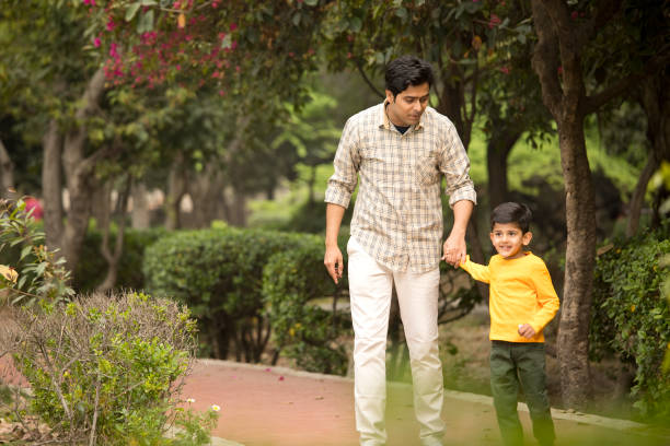 istock Father with son walking at park 1386911738
