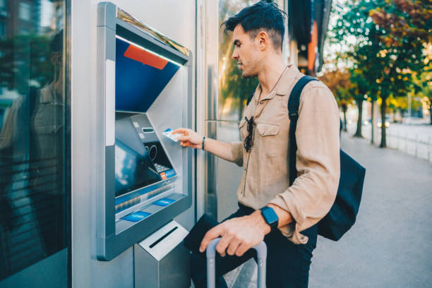 Tourist at the ATM withdrawing cash with credit card stock photo
