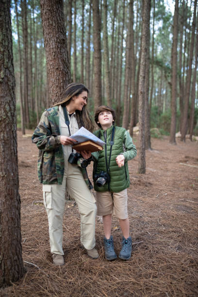 istock Contented family with cameras walking in forest 1386914554