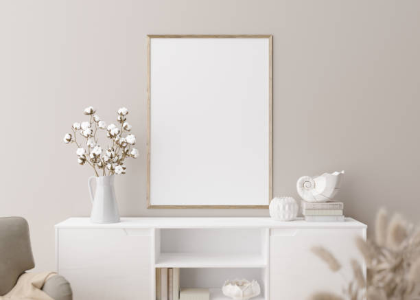 istock Empty vertical picture frame on cream wall in modern living room. Mock up interior in minimalist, scandinavian style. Free, copy space for picture. Console, armchair, cotton plant, vase. 3D rendering. 1386917754