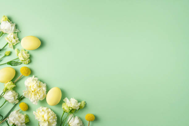 istock Festive Easter composition. Tender fresh white and yellow flowers and coloured chicken eggs on light green background. Eco spring template. Blooming holiday layout. Copy space, top view, flat lay 1386919668
