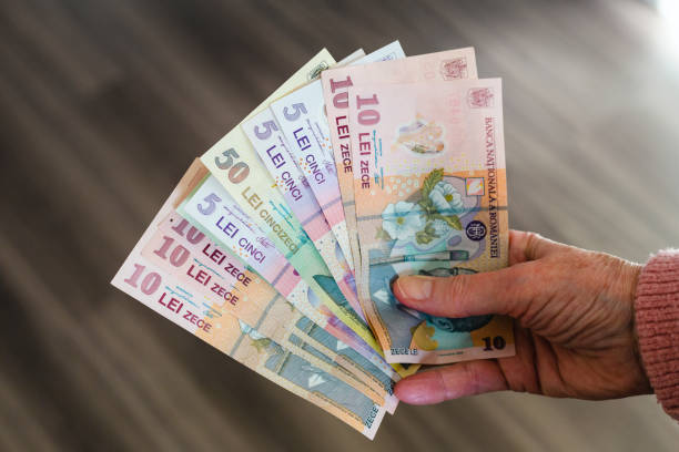 istock Hand holding stack of Romanian paper currency 1386922204