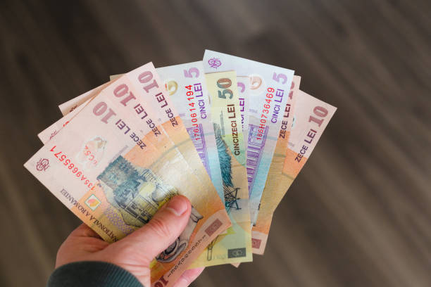istock Hand holding stack of Romanian paper currency 1386922215