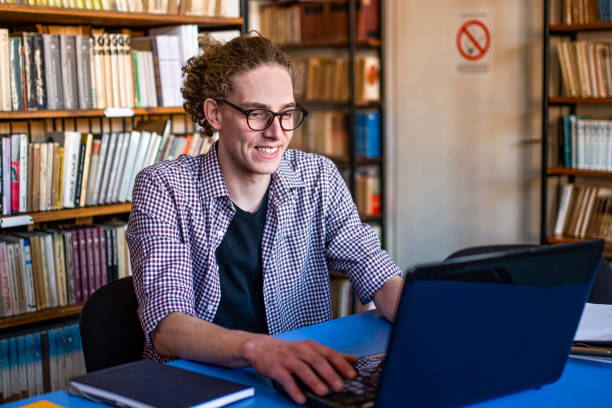 istock Student in the library use a laptop stock photo 1386922470