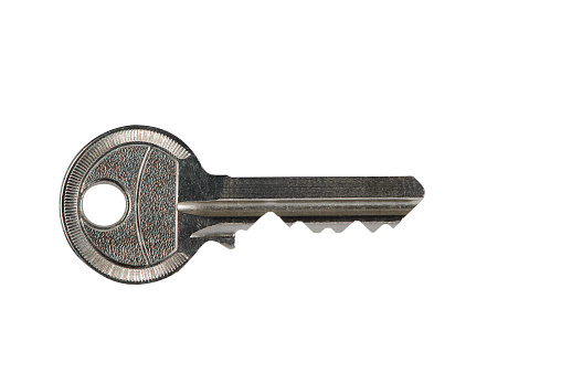 Cylinder key, used with scratches and decorative embossing, front view. A high resolution XXL image, isolated on white, clipping path.