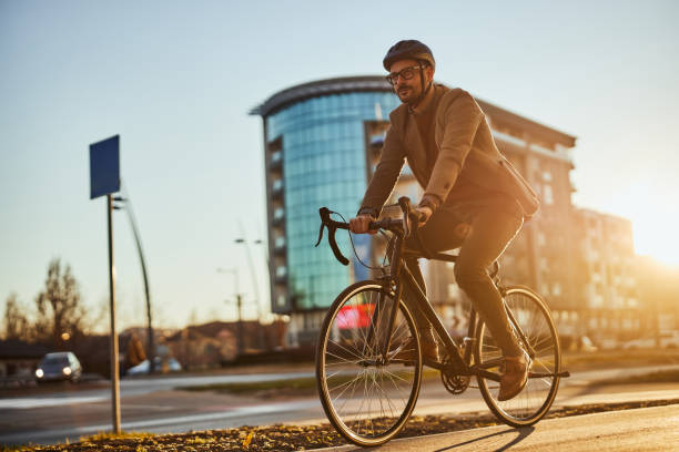 jeune homme d’affaires élégant allant travailler par vélo - city bike photos et images de collection