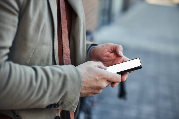 istock Male hands typing on smartphone outdoors 1386930783