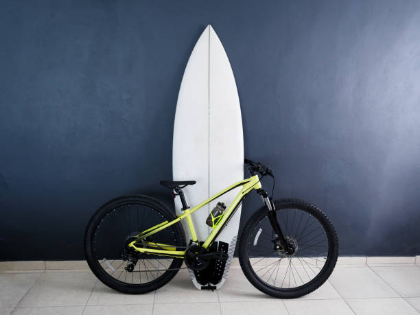 Yellow black 29er mountain bike with white surfboard.