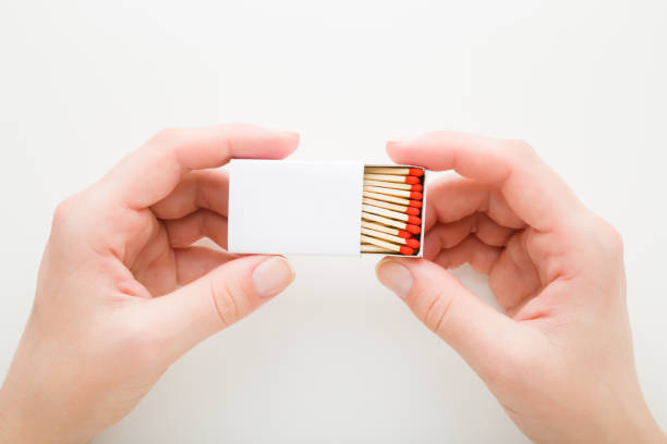 Young adult woman hand holding and showing opened box of match sticks on white background. Closeup. Point of view shot. Top down view. Young adult woman hand holding and showing opened box of match sticks on white background. Closeup. Point of view shot. Top down view. unlit match stock pictures, royalty-free photos & images