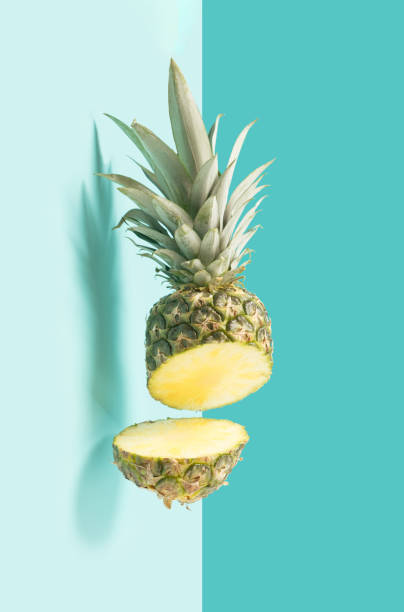istock Fresh pineapple cut in half in the air on pastel blue background. 1386935249