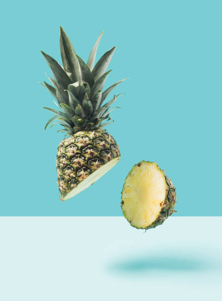 istock Fresh pineapple cut in half in the air on pastel blue background. 1386935261