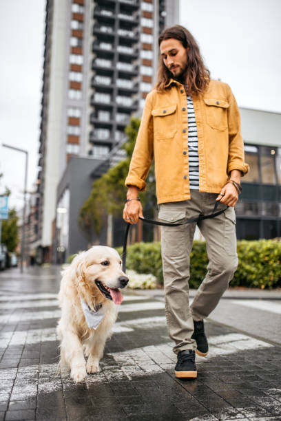 istock Young man and his dog walking on a rainy day 1386938349