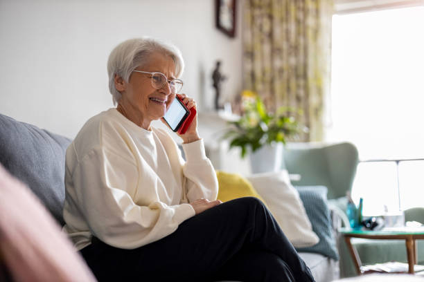 istock Senior woman using mobile phone at home 1386938998