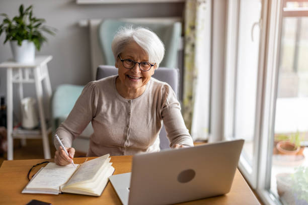 istock Senior woman using laptop at home 1386939724