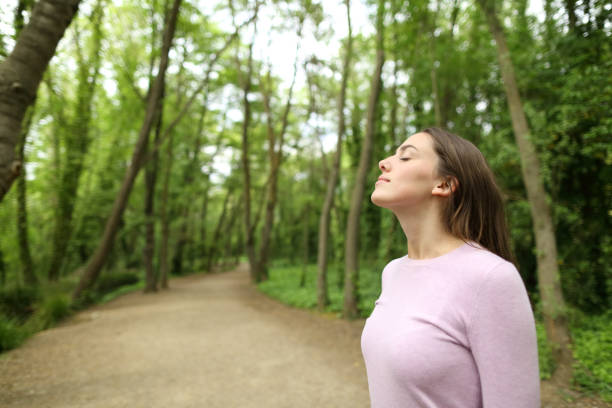 istock Woman breathing in a forest or park 1386939850