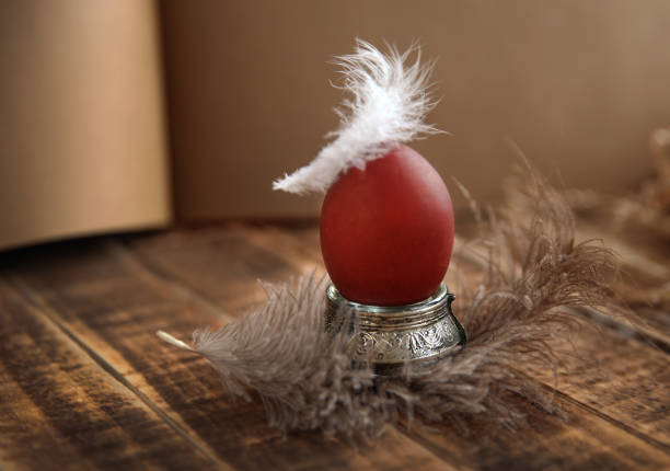 Easter egg on a stand, dyed with natural dye, feathers. Copy space. Selective focus