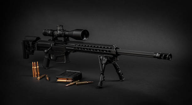 istock Modern powerful sniper rifle with a telescopic sight mounted on a bipod. Ammo and an additional magazine next to the rifle. 1386942381