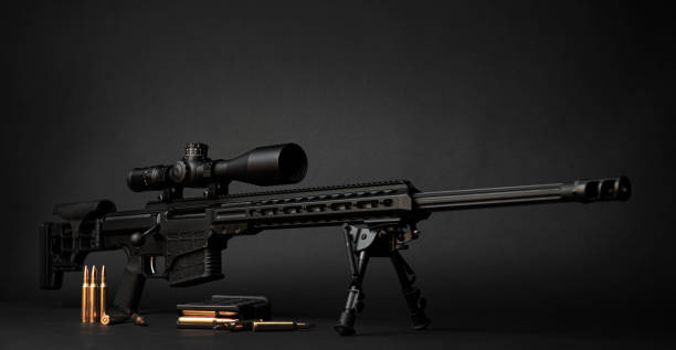 istock Modern powerful sniper rifle with a telescopic sight mounted on a bipod. Ammo and an additional magazine next to the rifle. 1386942382