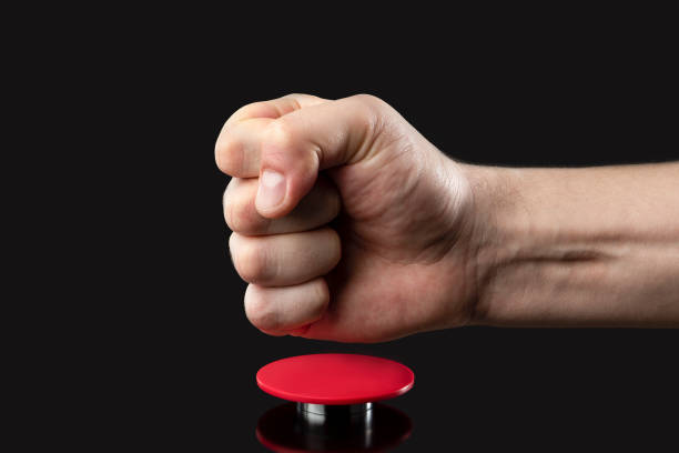 istock A man's hand presses a big red button. Red button on a dark background. The threat of using nuclear or chemical weapons of mass destruction. Rocket launch at the push of a button 1386943521