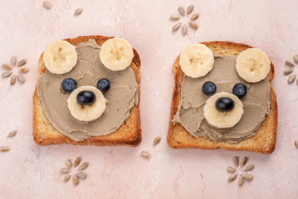 istock Funny children bear toasts with nuts butters for breakfast 1386946483