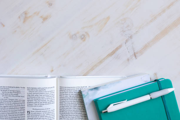 istock Border of open bible and teal journal on white 1386946920