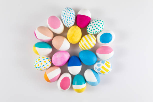 Colorful eggs painted in pastel colors in circle shape on white background