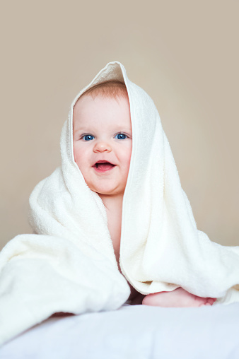 Cute baby 7 months old in white towel.
