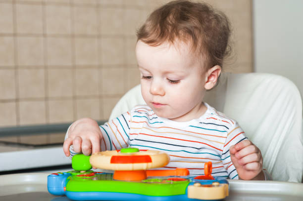 istock Boy Toddler plays toy at feeding table close-up.. 1386947624