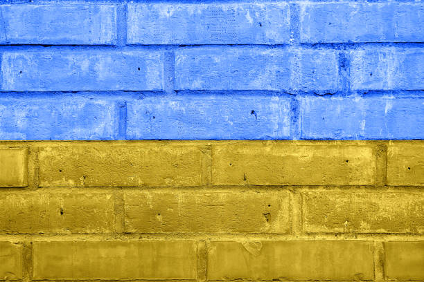 istock Ukraine flag painted on old brick wall texture background 1386948140