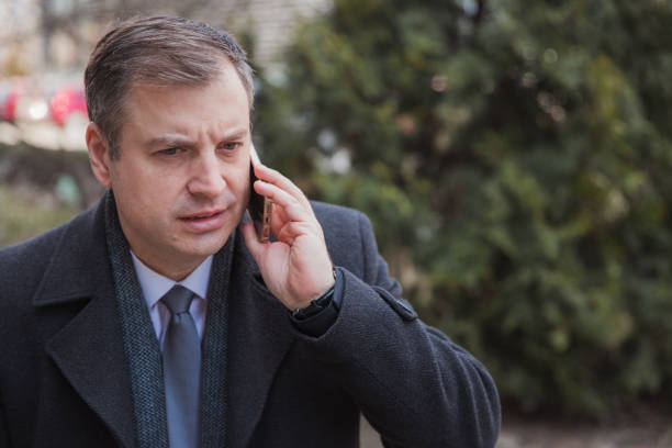 istock Worried businessman having phone conversation, close-up 1386948234