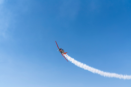 Vintage biplane does loop stunt with smoke trails. airplane