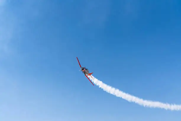 Vintage biplane does loop stunt with smoke trails. airplane
