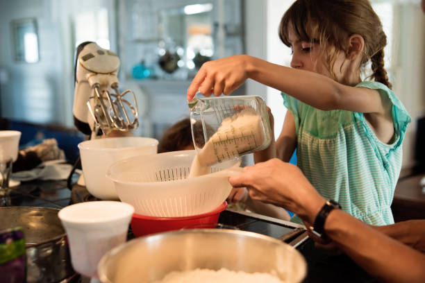 istock Mother and young daughter baking a cake at home. 1386950669