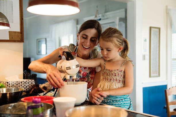 istock Mother and young daughter baking a cake at home. 1386950688