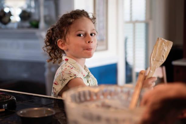 istock Little girl tasting a preparation at home. 1386950903
