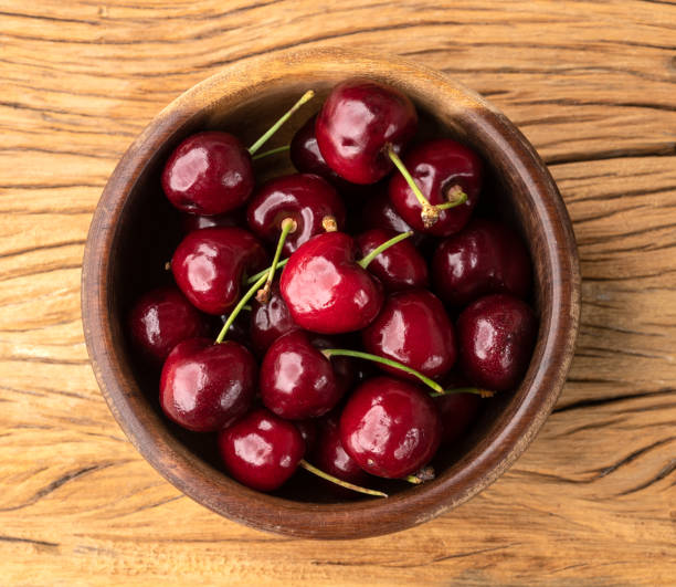 istock Red cherries on a bowl over wooden table 1386953608
