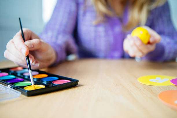 Woman painting easter eggs, close-up