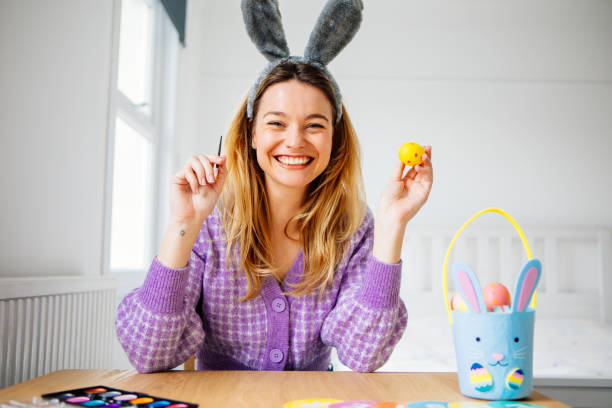 Beautiful woman painting easter eggs