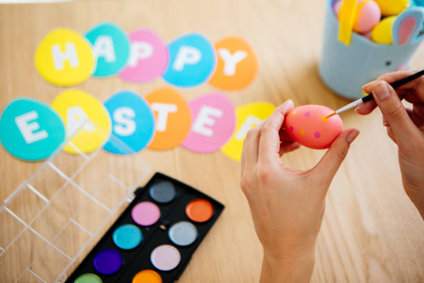 Woman painting easter eggs, close-up