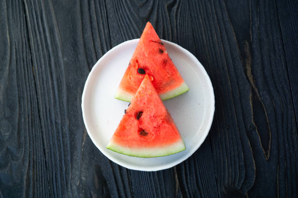 istock Fresh watermelon on a wooden kitchen board on a blue background 1386955806