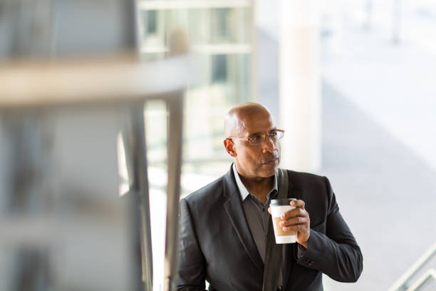 istock African American businessman walking and drinking coffee. 1386959467