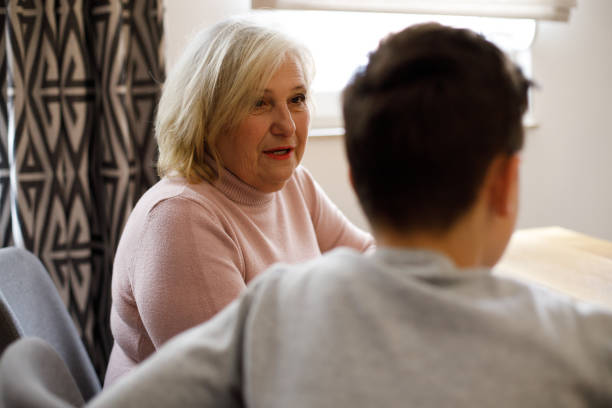 istock Boy speaking and sharing secret with grandmother 1386961423