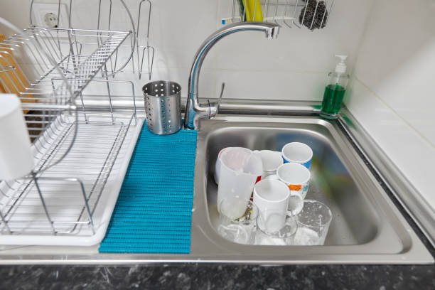 istock Sink with glasses and cups with soap 1386963197