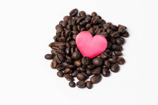 istock Close-up Roasted coffee beans and red heard on middle on white background. 1386964313